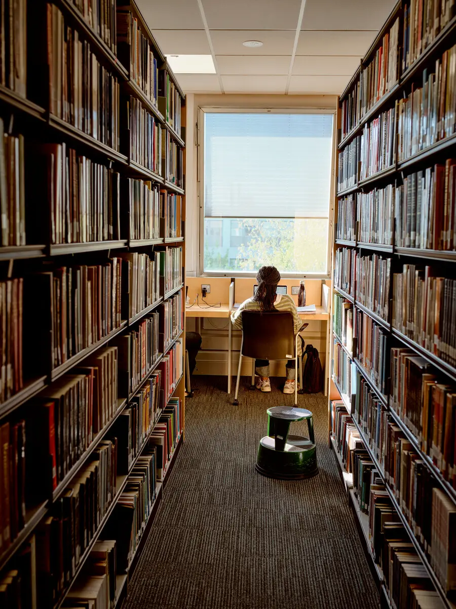 A student in a red top looking back over their shoulder.