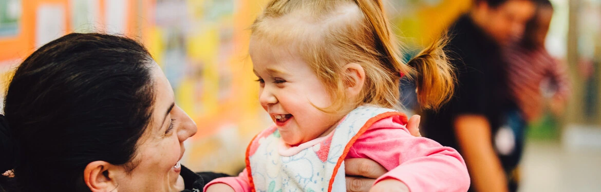 An early years staff member engaging with a child in an education setting