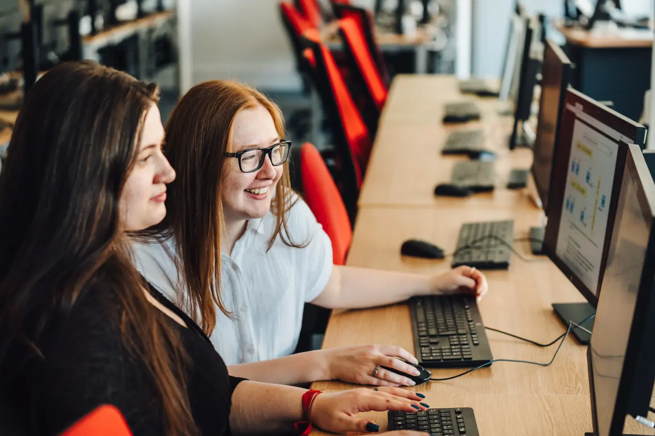 Two students working at computers on campus