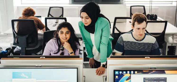 An academic supporting students in a computer lab