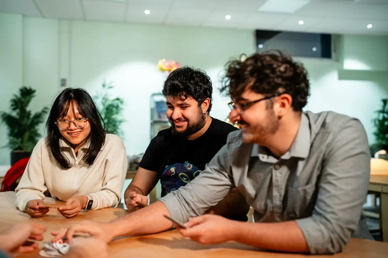 A group of students enjoying playing a card game together.