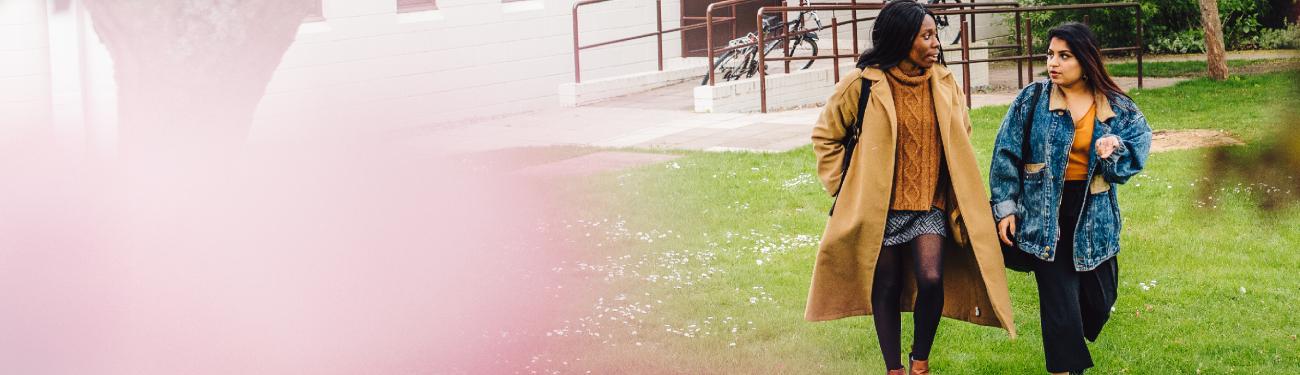 This image shows two students talking whilst walking on the University of Warwick campus