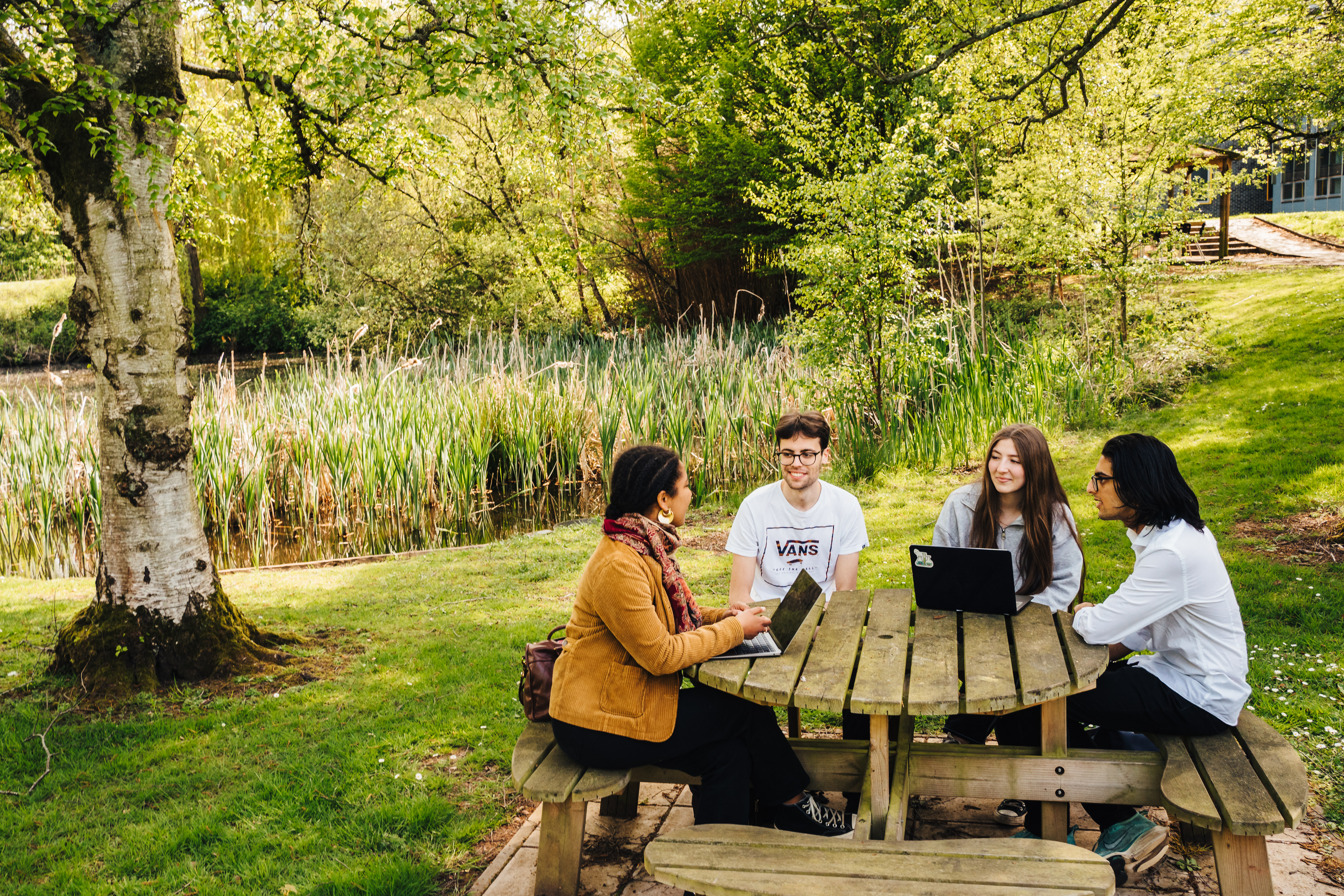 Some students sitting on campus and doing research/ group assignment