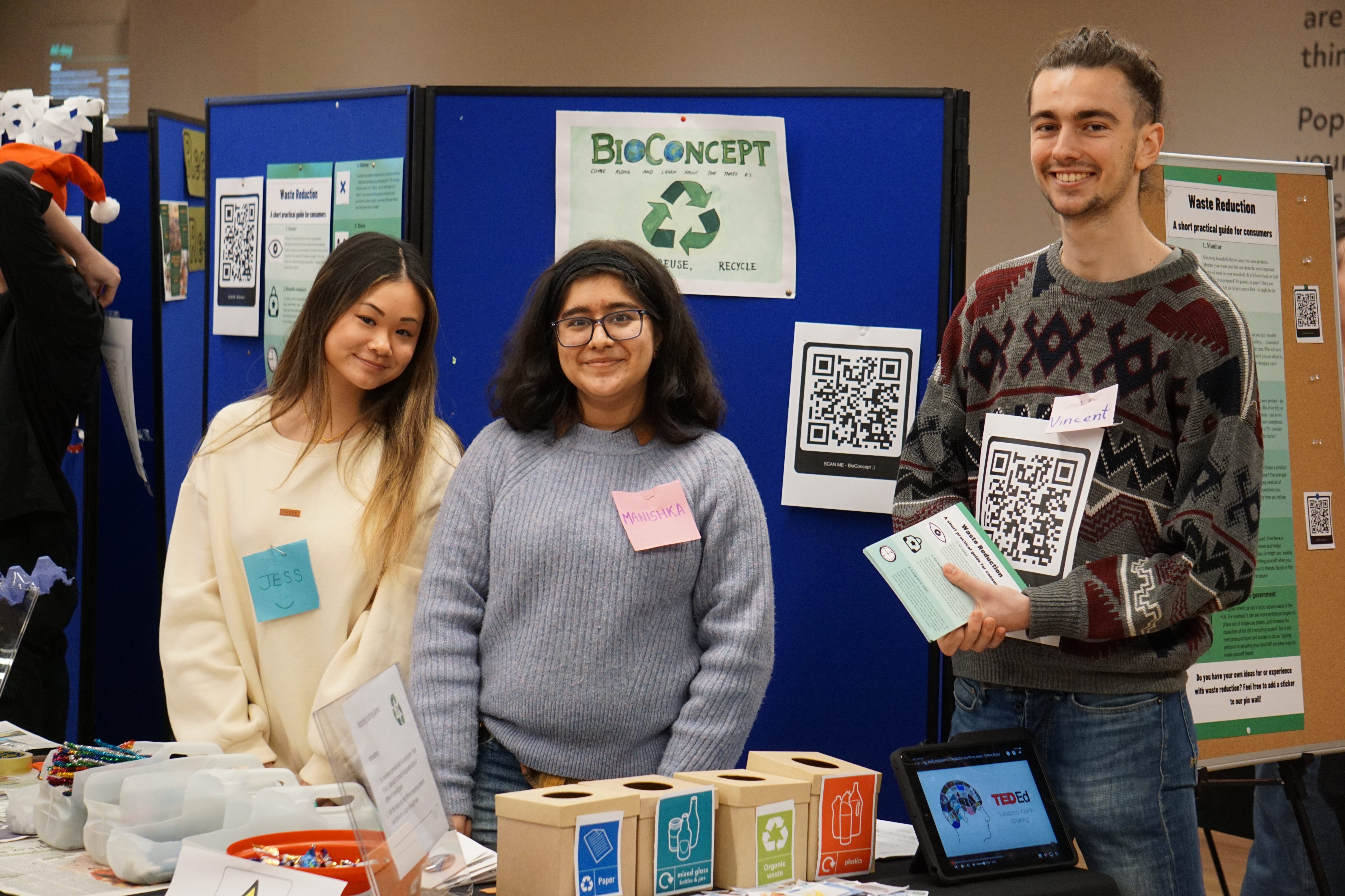 Three students running an activity based on recycling