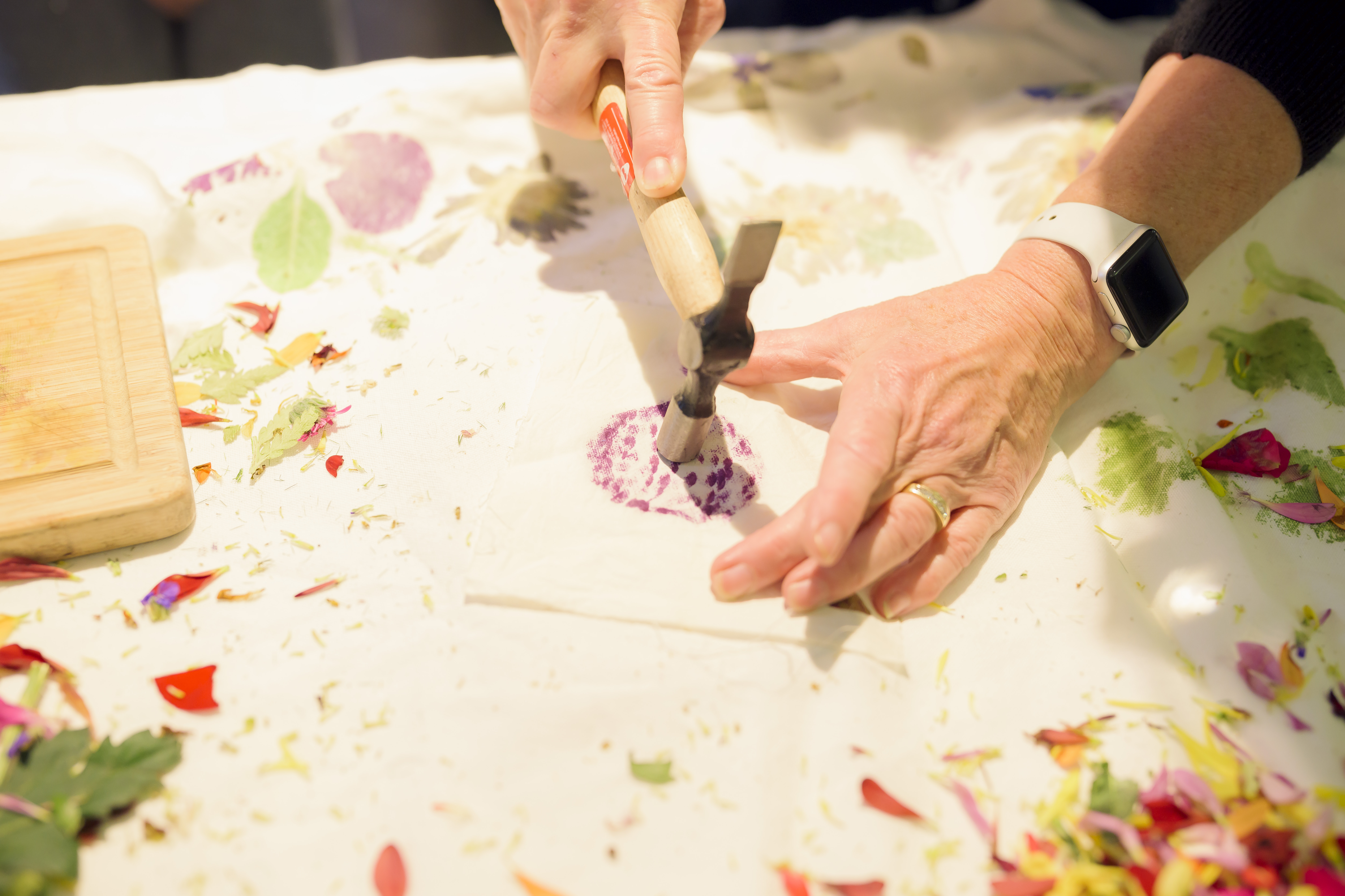 Hand hammering flowers into fabric