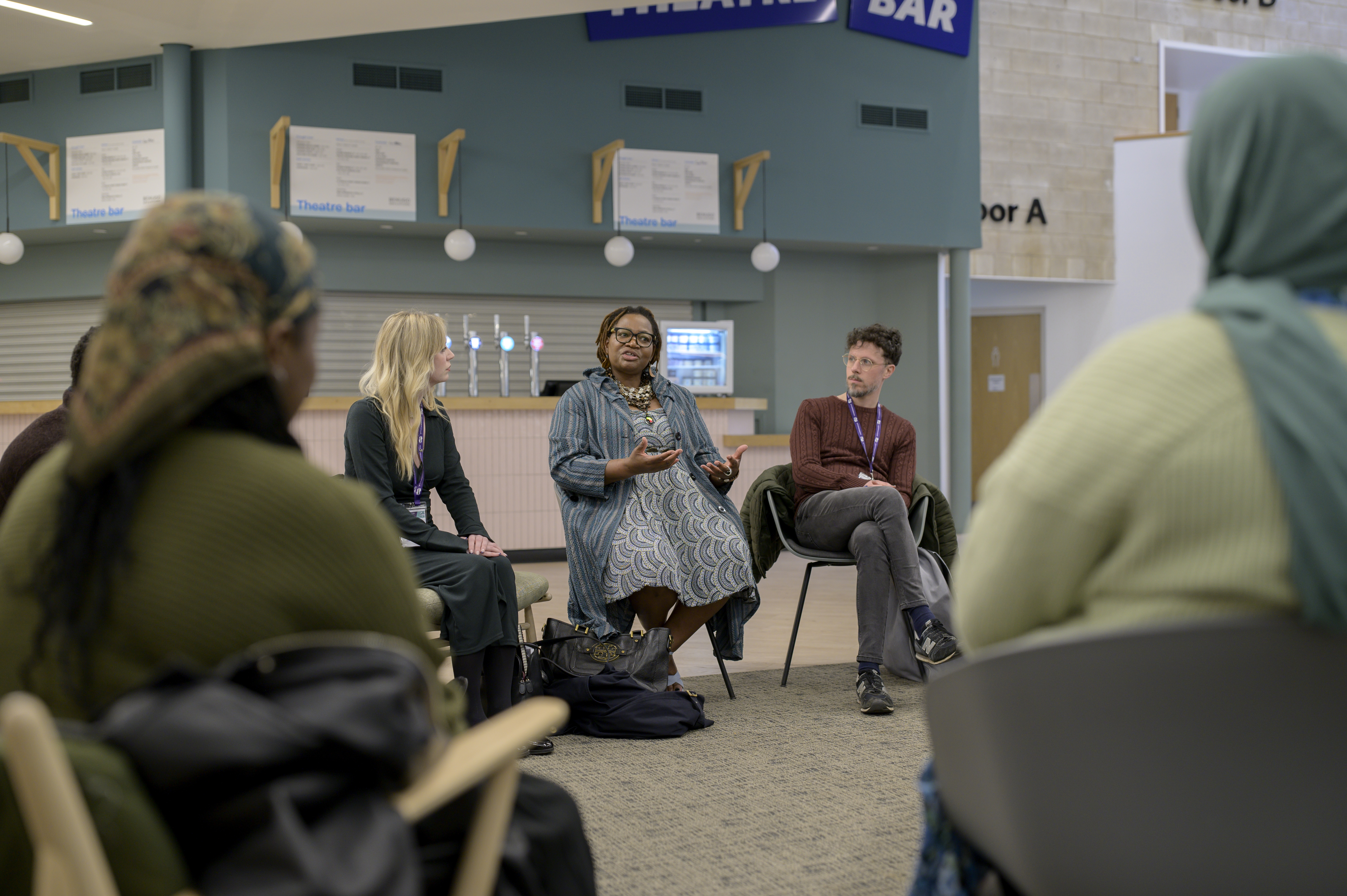 A group sat in a circle are talking together. 