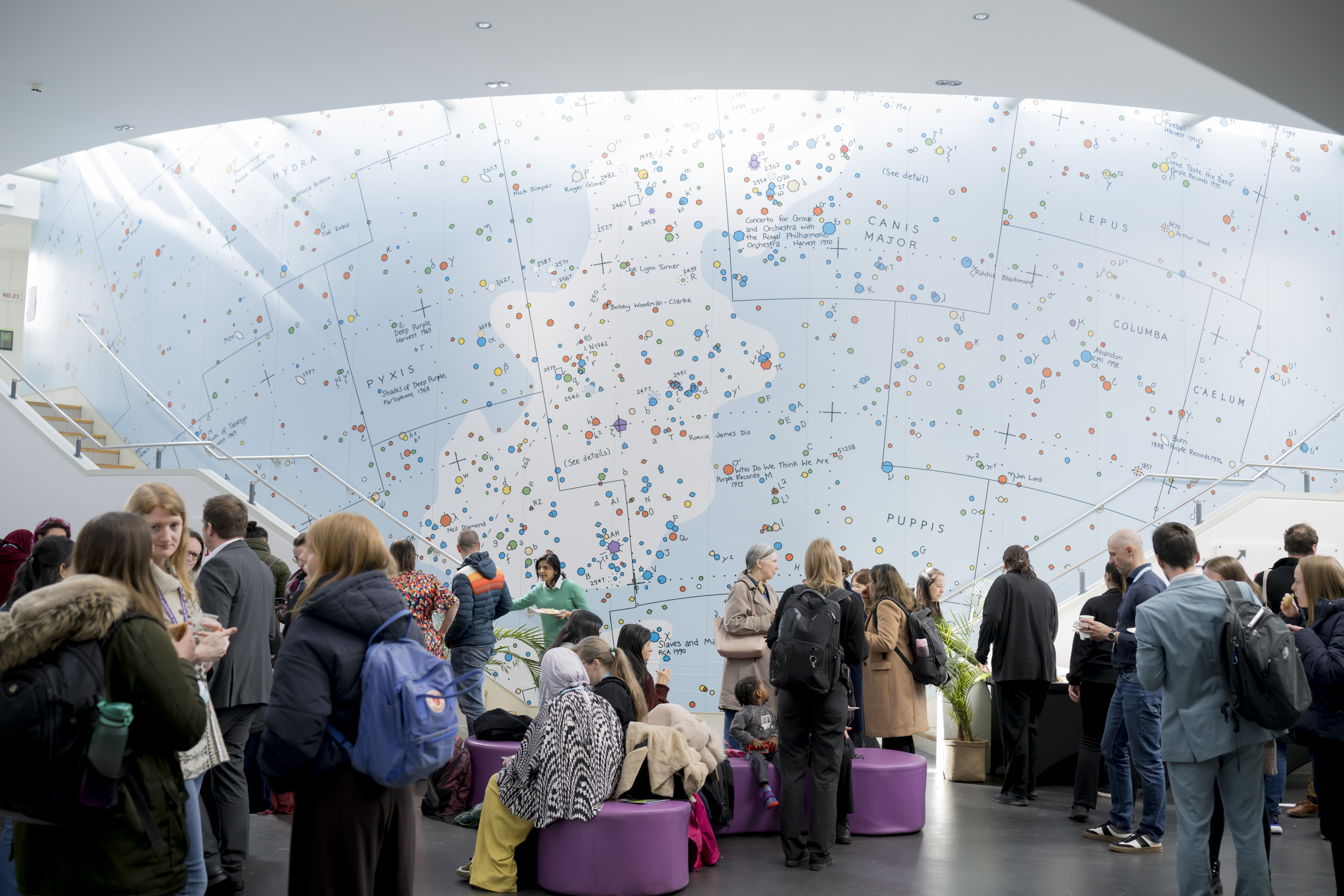 A crowd of people chatting in the Ramphal Building at University of Warwick