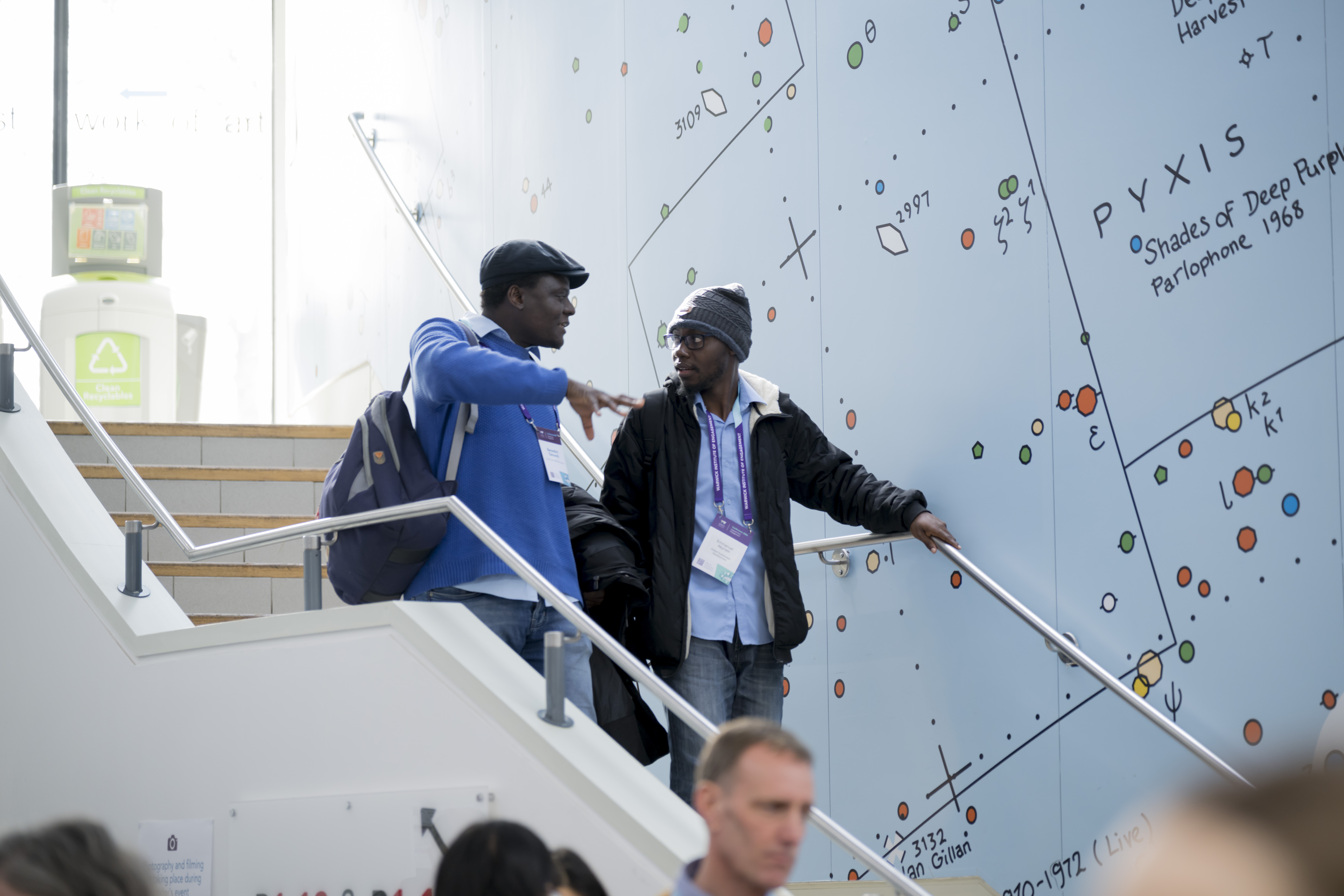 Two people chatting as they are walking down a flight of stairs
