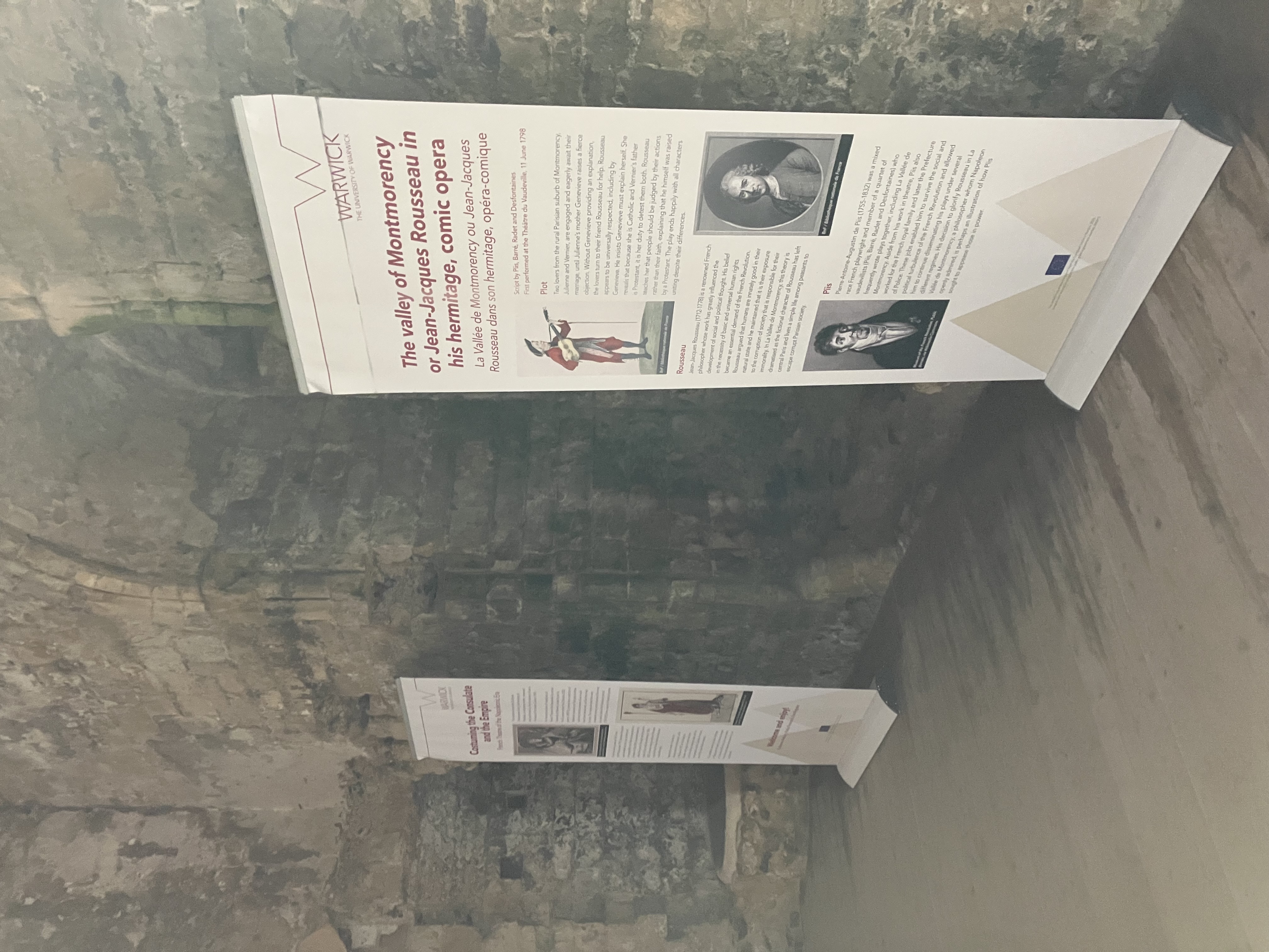 Two banners standing on either side of an archway in a stone castle.