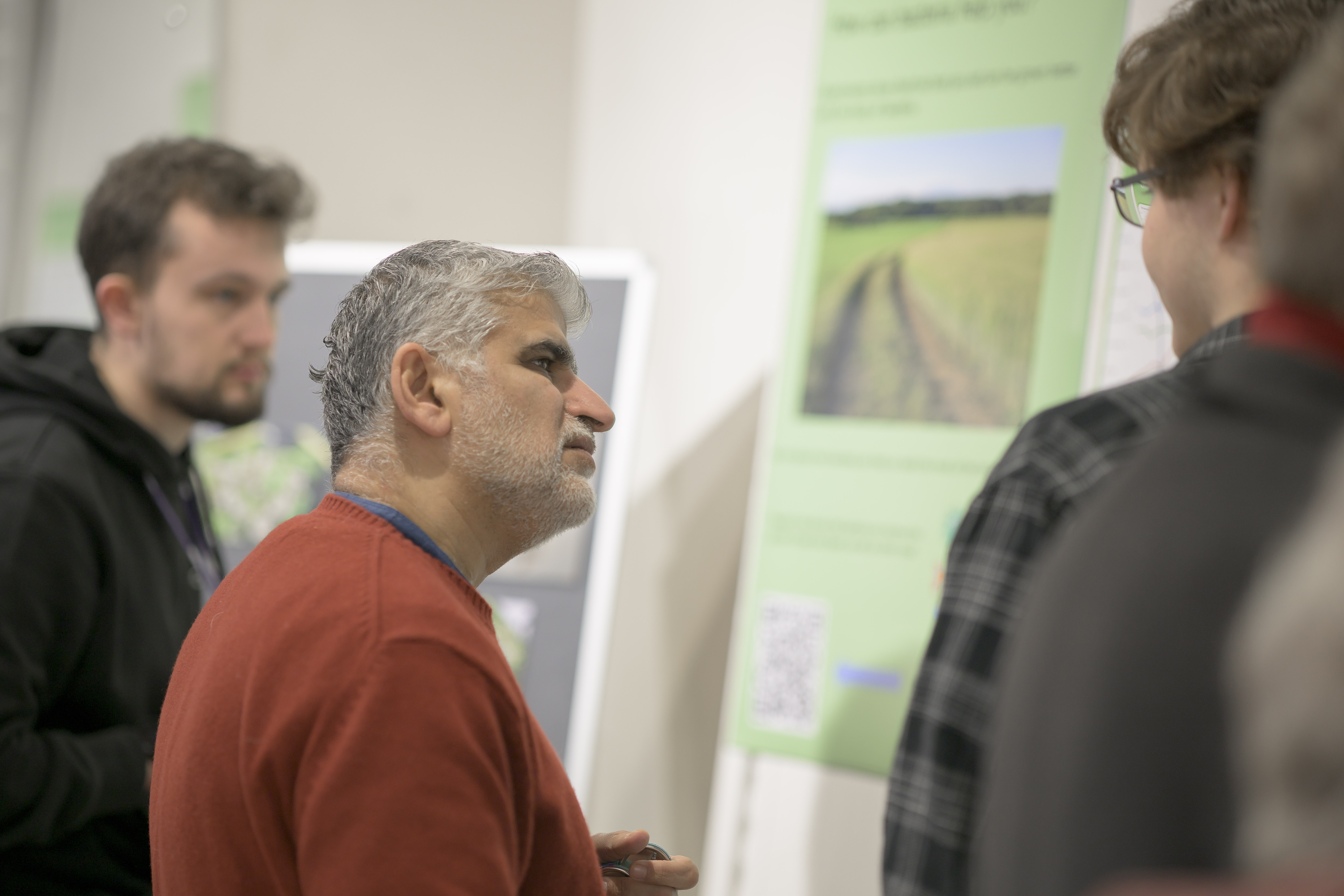 A visitor listening intently to a student. 