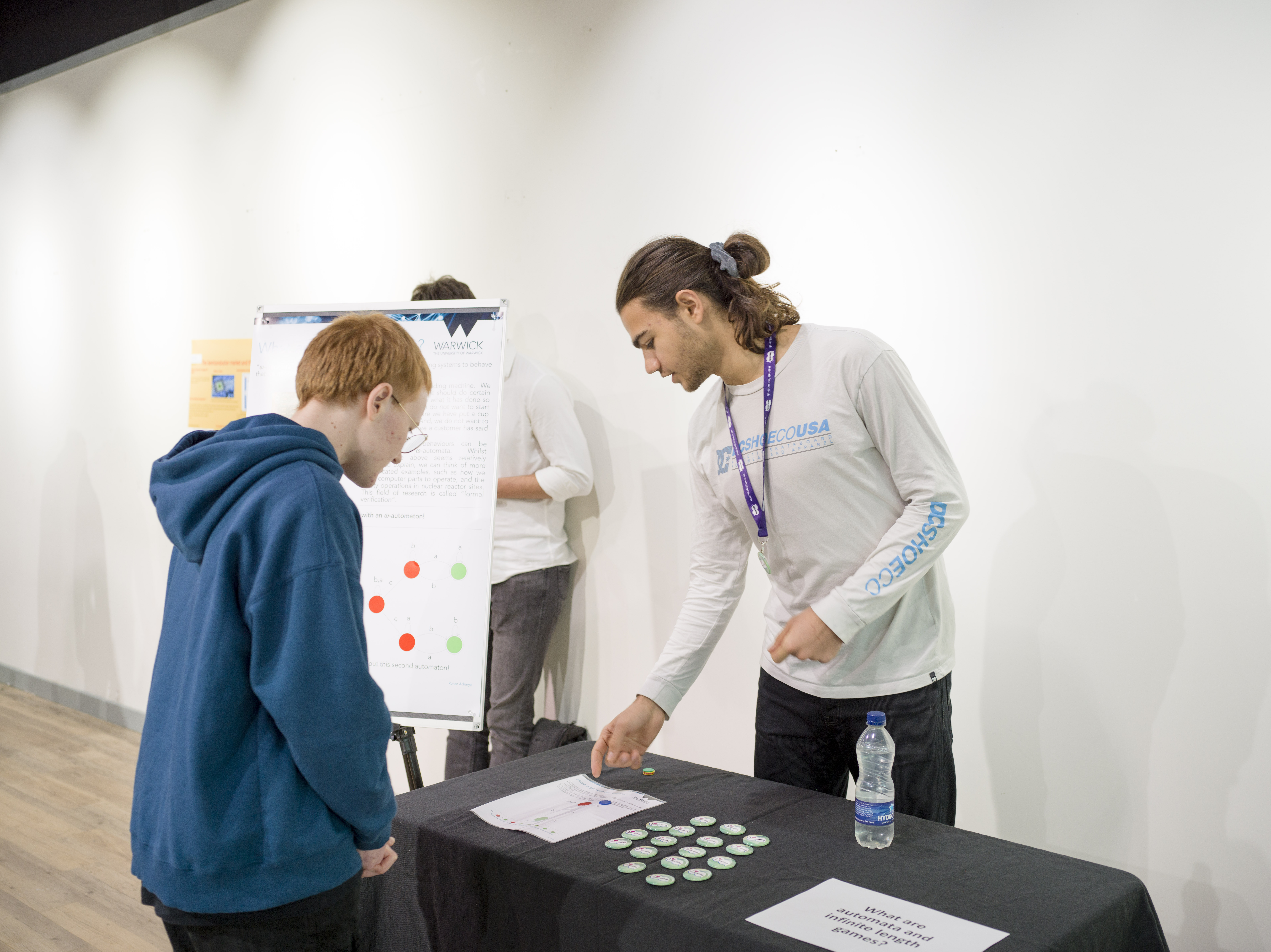 A student shows a visitor a diagram with counters to move around it.