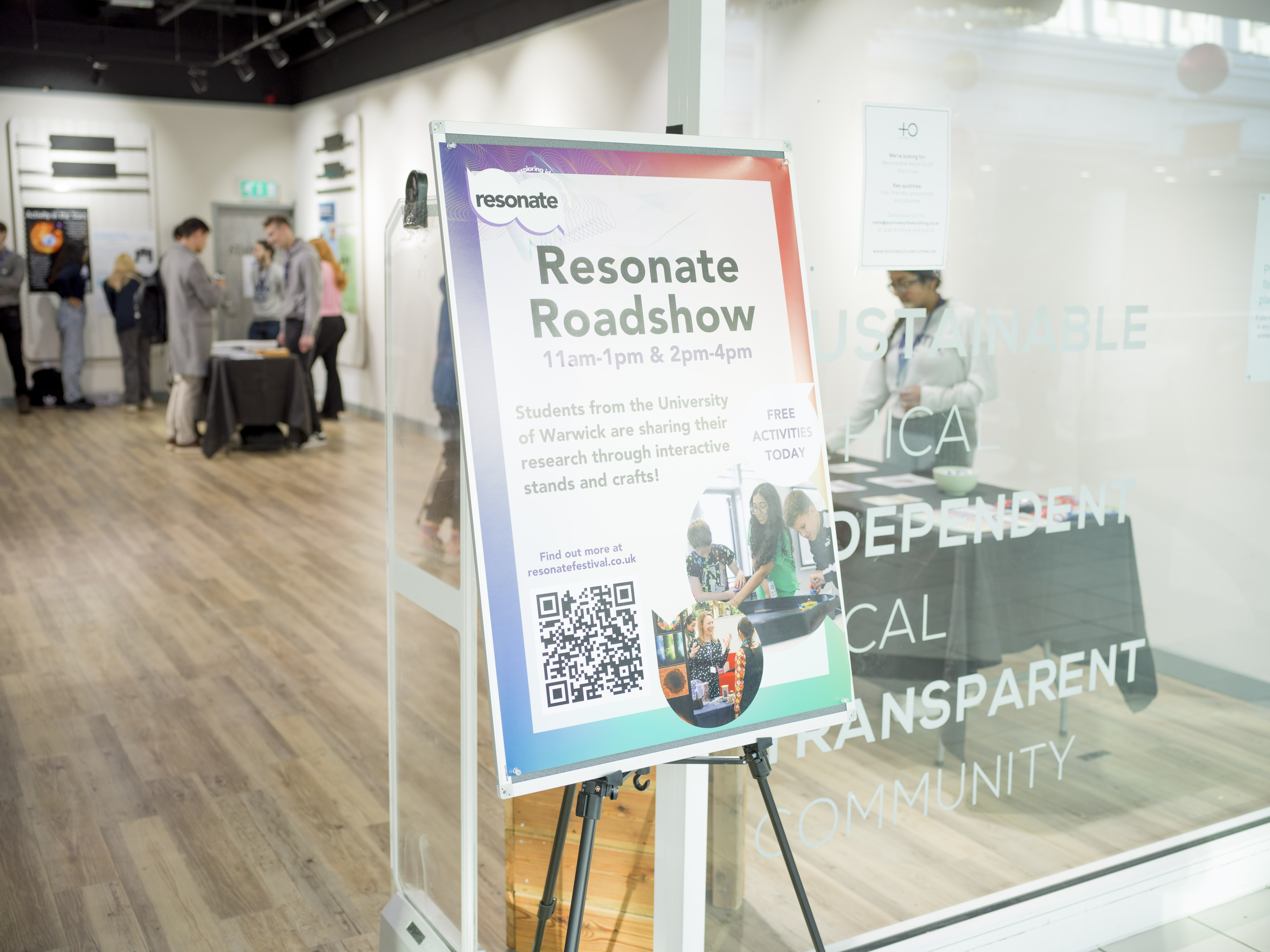 By the doorway of a shop, a poster that says Resonate Roadshow