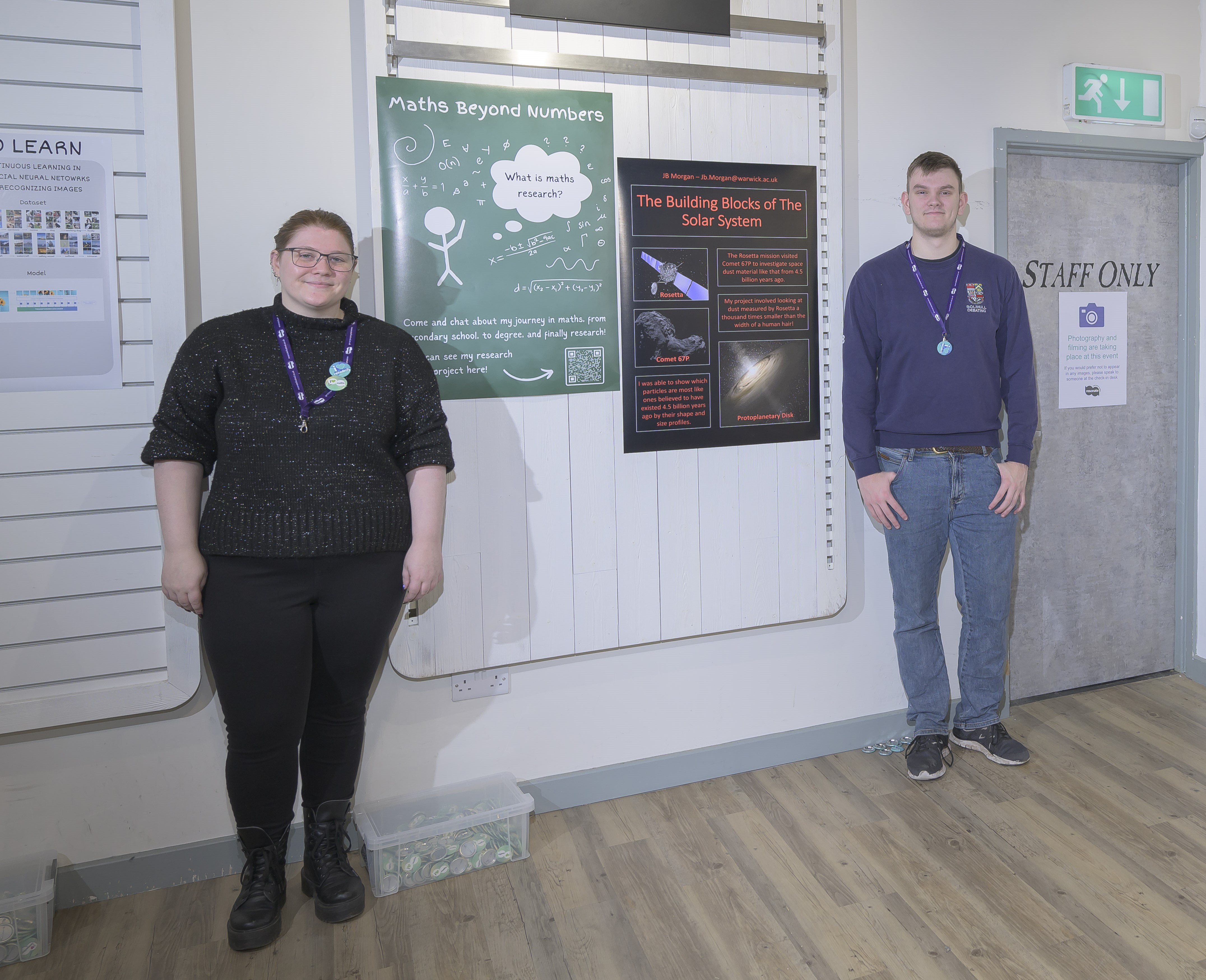 Two students standing with their posters. 