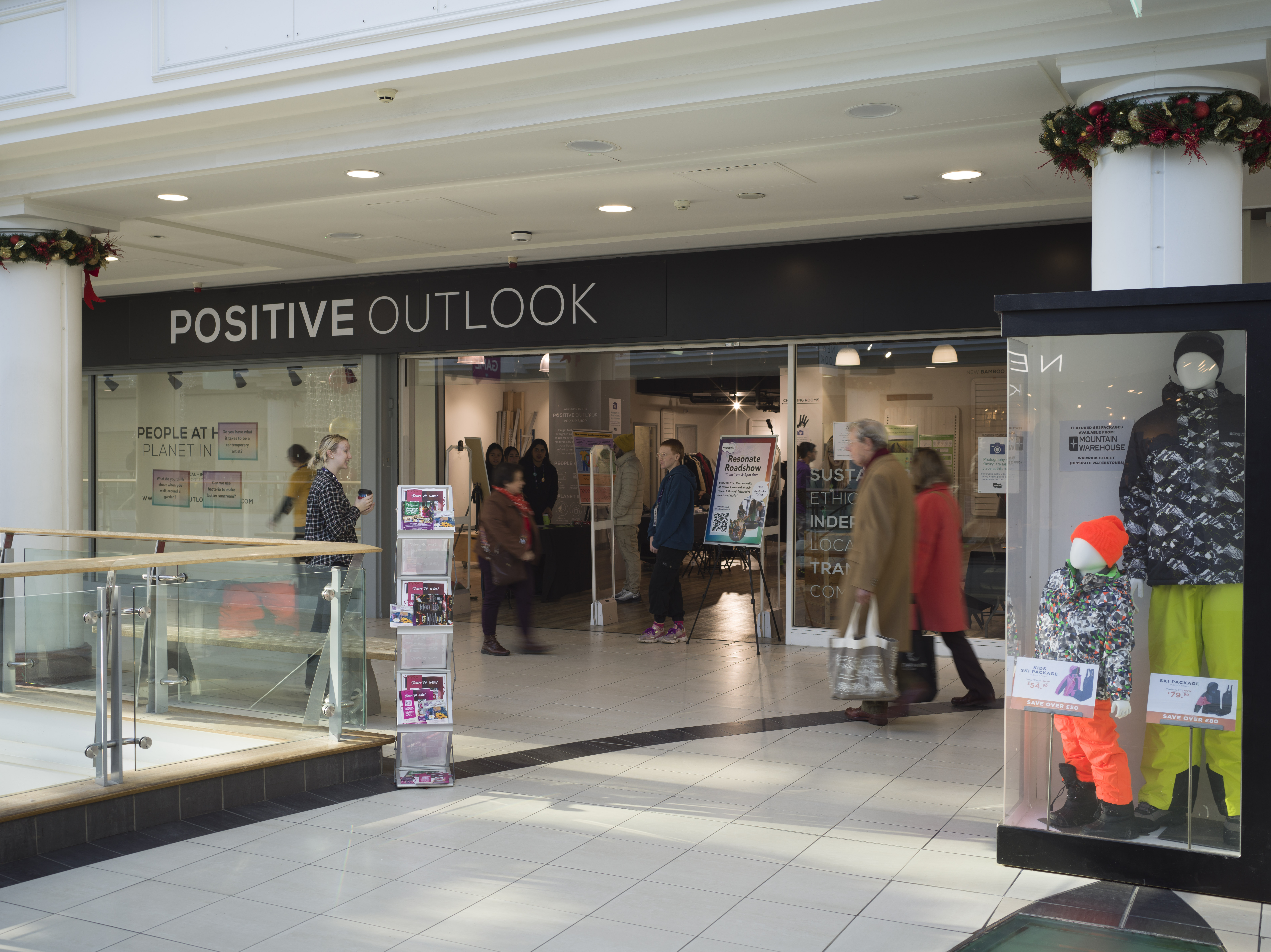 A shopping centre interior showing the entrance to a shop called Positive Outlook. 