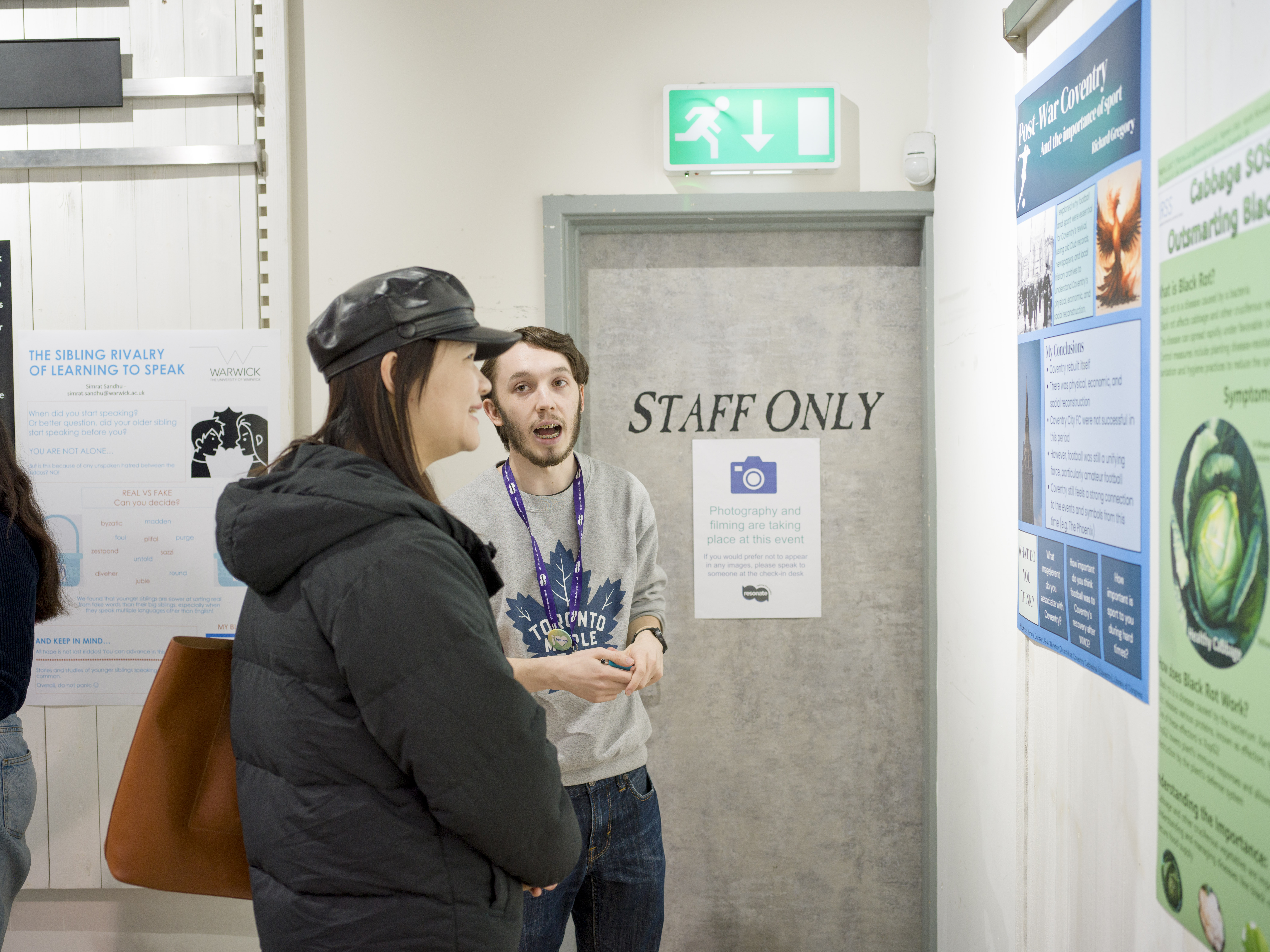 A student talks to a visitor about their poster. 