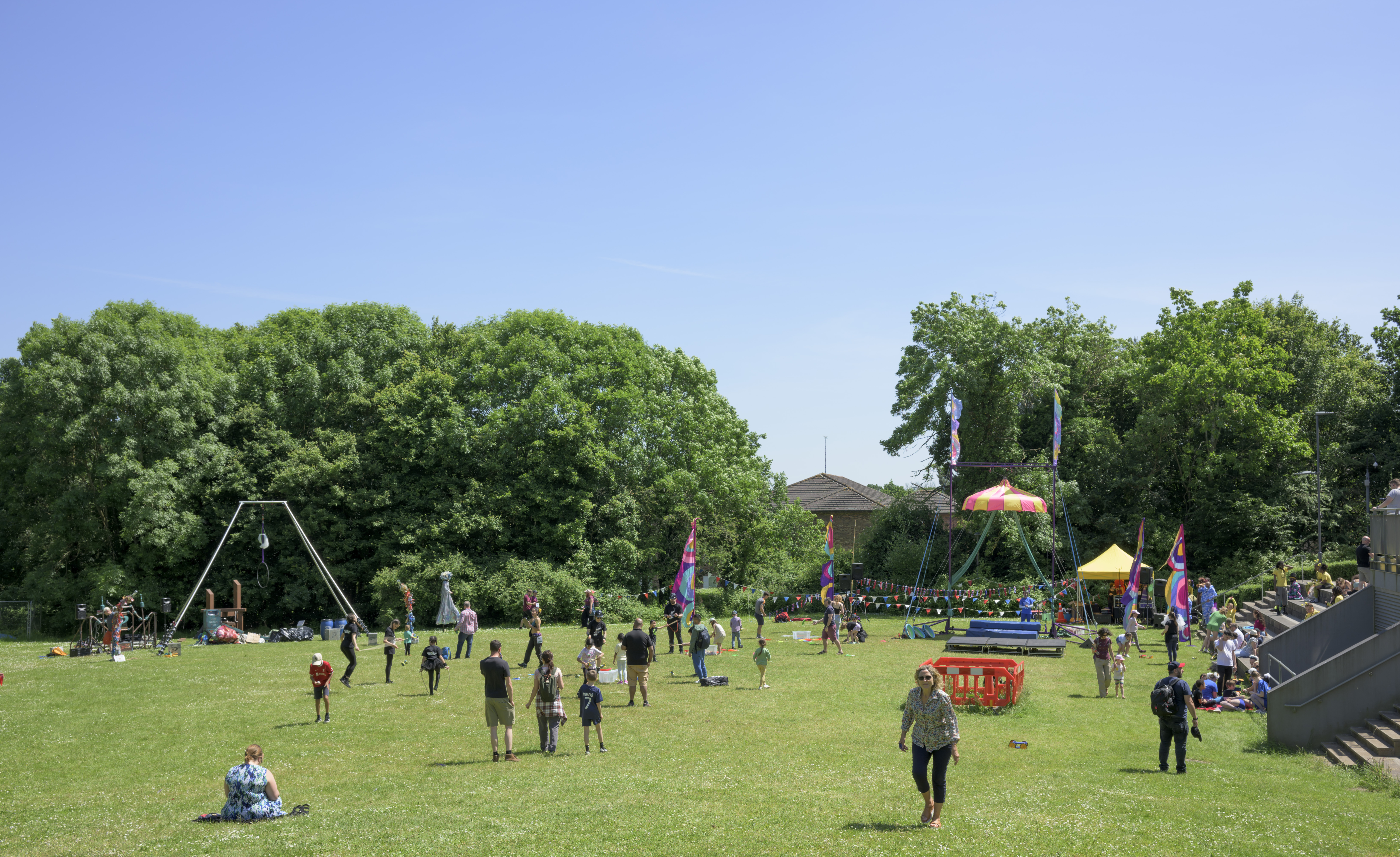 People standing in a field with circus equipment 