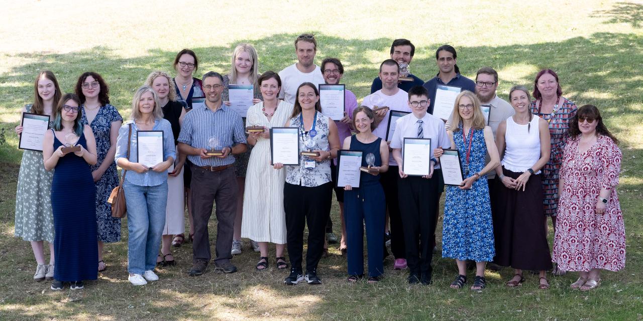 Award winners holding up trophies and certificates 