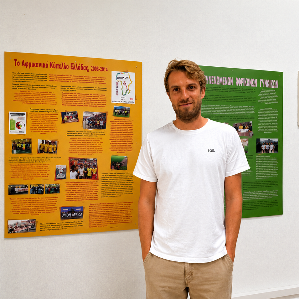 Oska Paul stood next to posters about his exhibition