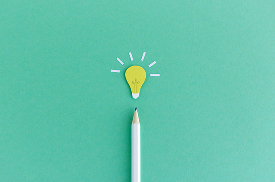 (Decorative) Green background, pencil pointing at a lightbulb
